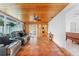 Living room features gray sectional, wood-paneled ceiling, and terracotta tile floors at 1841 Buccaneer Dr, Sarasota, FL 34231