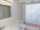 Bathroom with a marble countertop, toilet, and a unique glass block window at 6555 Connecticut Ave, Sarasota, FL 34243