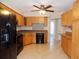Eat-in kitchen showcasing honey oak cabinets, neutral countertops, and black appliances at 6555 Connecticut Ave, Sarasota, FL 34243
