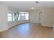 Bright living room featuring a large window, neutral tile flooring, and a white door at 6555 Connecticut Ave, Sarasota, FL 34243