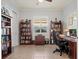 Well-lit home office, featuring a large desk and ample bookshelves at 5130 Tidewater Preserve Blvd, Bradenton, FL 34208