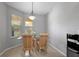 Small dining area with striped chairs and corner window at 7187 Boca Grove Pl # 202, Lakewood Ranch, FL 34202