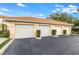 Three-car garage with individual doors and landscaping at 7187 Boca Grove Pl # 202, Lakewood Ranch, FL 34202