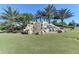 Community entrance with a waterfall feature and landscaping at 115 Winding River Trl, Bradenton, FL 34212