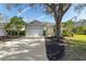 House exterior featuring a two-car garage and mature trees at 6427 Golden Leaf Ct, Lakewood Ranch, FL 34202