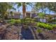 House with gray siding, mature landscaping, and palm trees at 3161 Bayou Sound, Longboat Key, FL 34228