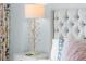 Closeup of bedroom with a stylish bedside lamp and tufted headboard at 111 S Pineapple Ave # 613, Sarasota, FL 34236