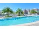 Relaxing swimming pool area featuring tropical landscaping, lounge chairs, and views of city buildings at 111 S Pineapple Ave # 613, Sarasota, FL 34236