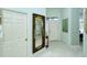 Inviting hallway features tile flooring, elegant mirror and leads to the front entrance at 111 Woodbridge Dr # 202, Venice, FL 34293