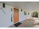 Modern front entrance with an orange door and stone patio at 5246 Bay Shore Rd, Sarasota, FL 34234