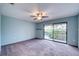 Bright bedroom featuring a sliding glass door to balcony overlooking a tranquil lake at 947 Sunridge Way # A-3, Sarasota, FL 34234