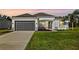 Charming one-story home with gray garage door, lush lawn, and stone details at 12928 24Th E Ct, Parrish, FL 34219