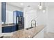 Close-up of modern kitchen featuring granite countertop, stainless steel appliances, and blue cabinets at 12928 24Th E Ct, Parrish, FL 34219