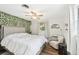 Bedroom with ceiling fan, leafy wall, and wood floors at 2947 Arrowhead Rd, Venice, FL 34293