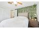 Bedroom with a ceiling fan and leafy accent wall at 2947 Arrowhead Rd, Venice, FL 34293