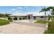 Tan house with metal roof, paver driveway and patio, and lush landscaping at 3630 Verna Rd, Myakka City, FL 34251