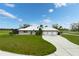 Single-story home with a large yard, three-car garage, and circular driveway at 3630 Verna Rd, Myakka City, FL 34251
