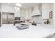 White kitchen with island, stainless steel appliances, and a large window at 3630 Verna Rd, Myakka City, FL 34251
