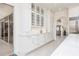 White kitchen with glass-front cabinets and a view of the backyard at 3630 Verna Rd, Myakka City, FL 34251
