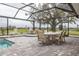 Covered patio with table and chairs near the refreshing pool at 3630 Verna Rd, Myakka City, FL 34251