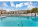 Community pool with condo building in background at 1215 S Portofino Dr # 404, Sarasota, FL 34242