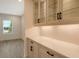 Bright butler's pantry with white cabinets, quartz countertops, and glass-front shelving at 2528 Star Apple Way, Sarasota, FL 34240