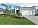 Two-story house with gray exterior, white garage door, and landscaped yard at 2528 Star Apple Way, Sarasota, FL 34240