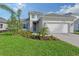 Two-story house with gray exterior, white garage door, and landscaped yard at 2528 Star Apple Way, Sarasota, FL 34240