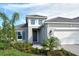 Two-story house with gray exterior, white garage door, and landscaped yard at 2528 Star Apple Way, Sarasota, FL 34240