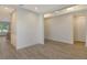 Bright hallway with neutral walls and wood-look tile flooring, offering views into other rooms at 2528 Star Apple Way, Sarasota, FL 34240