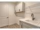 Laundry room with cabinets, sink, and overhead shelving at 2528 Star Apple Way, Sarasota, FL 34240