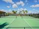 A community tennis court boasts palm tree views and an open sky for match play at 5553 Mulligan Way, Bradenton, FL 34211