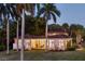 House exterior with palm trees and waterfront view at dusk at 4511 Bay Shore Rd, Sarasota, FL 34234