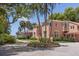 Pink two-story home with a circular driveway and lush landscaping at 4511 Bay Shore Rd, Sarasota, FL 34234