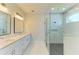 Modern bathroom featuring double sinks, a marble shower, and contemporary lighting at 1010 Acadia Rd, Venice, FL 34293