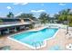 Community pool with surrounding lounge chairs and patio tables at 7201 29Th Avenue W Dr # 306, Bradenton, FL 34209