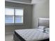 Main bedroom with a large bed, window with plantation shutters and lake view at 1045 Crosswind Ave, Sarasota, FL 34240