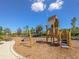 Community playground with wooden playset, swings, and ample woodchip surface at 1045 Crosswind Ave, Sarasota, FL 34240