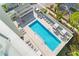 Elevated view of resort-style pool with lounge chairs and outdoor kitchen at 111 Golden Gate Pt # 602, Sarasota, FL 34236