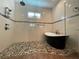 Shower with a rainfall shower head and freestanding tub in tiled bathroom with mosaic floor at 15618 Castle Park Ter, Lakewood Ranch, FL 34202