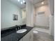 Bathroom featuring vanity with black granite countertop, shower/tub, and tile flooring at 15618 Castle Park Ter, Lakewood Ranch, FL 34202