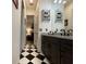 Elegant bathroom with black and white checkered flooring, granite countertops, and dual sinks at 15618 Castle Park Ter, Lakewood Ranch, FL 34202