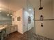 Bathroom featuring granite vanity, frameless shower with tiled walls, and decorative mosaic tile floor at 15618 Castle Park Ter, Lakewood Ranch, FL 34202