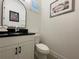 Half-bathroom with a vanity, black countertop, toilet, and framed art at 15618 Castle Park Ter, Lakewood Ranch, FL 34202