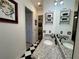 Bright bathroom with black and white checkered floors, granite countertops, and modern fixtures at 15618 Castle Park Ter, Lakewood Ranch, FL 34202