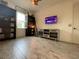 A well-lit room with a dark wood bookcase and whitewashed console under a wall-mounted television at 15618 Castle Park Ter, Lakewood Ranch, FL 34202