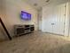 A bright room featuring wood-look flooring and a whitewashed console under a wall-mounted television at 15618 Castle Park Ter, Lakewood Ranch, FL 34202