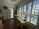 Bedroom with tiled floor, white cabinet, desk, and full length window with shutter and beautiful backyard view at 15618 Castle Park Ter, Lakewood Ranch, FL 34202