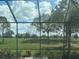 Through the screened enclosure the golf course view with trees and lush landscaping abounds at 15618 Castle Park Ter, Lakewood Ranch, FL 34202