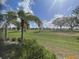 Relaxing backyard golf course view through the screened enclosure and tropical landscaping at 15618 Castle Park Ter, Lakewood Ranch, FL 34202